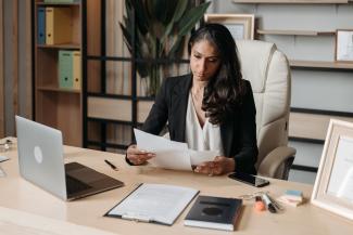 Businesswoman sitting at a desk and looking at some papers