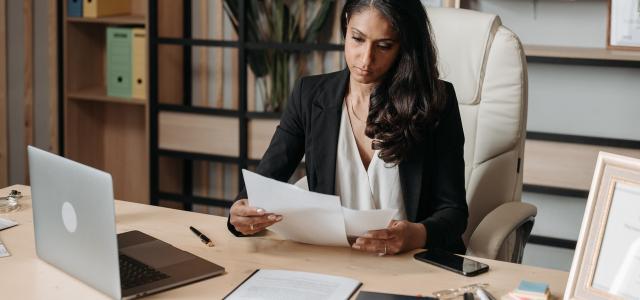 Businesswoman sitting at a desk and looking at some papers